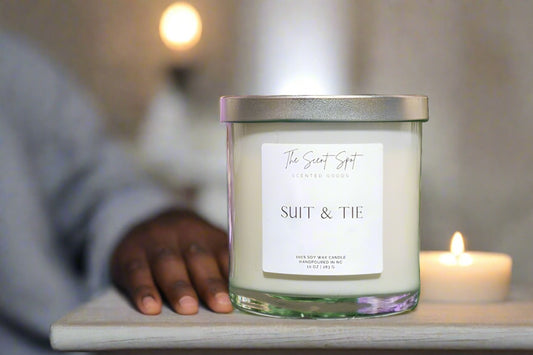 The Scent Spot Suit & Tie CandleCandleIlluminate your space with our soy wax candle, a captivating fusion of invigorating scents. At the top, experience the freshness of ozone and petitgrain, creating a Suit & Tie Candle